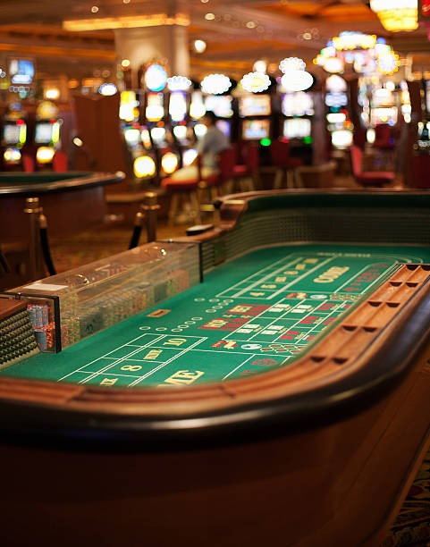 Close-up of three illuminated dice resting on a transparent gaming surface inside a studio cage